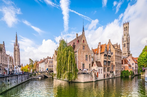Panoramic city view with Belfry tower and famous canal in Bruges